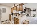 Well-maintained kitchen with wood cabinets, laminate countertops, and a breakfast bar at 10150 E Virginia Ave # 7-302, Denver, CO 80247