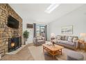 Bright living room featuring a stone fireplace, modern furniture, and a skylight at 10150 E Virginia Ave # 7-302, Denver, CO 80247