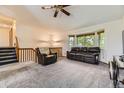 Cozy living room featuring a comfortable leather sofa, bay window, and plush carpeting at 5713 Whitechapel St, Castle Rock, CO 80104