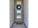 Welcoming front door with glass panels, a leafy wreath, and a 'hello' doormat at 18085 E 107Th Pl, Commerce City, CO 80022