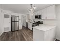 Modern kitchen with stainless steel appliances, white cabinets, and stylish flooring at 5532 Umatilla St, Denver, CO 80221
