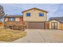 Two-story house with a brown garage door and wooden deck at 9359 W Lake Dr, Littleton, CO 80123