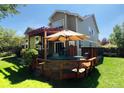 Deck with pergola, table, chairs, and surrounding greenery at 2834 S Fig St, Lakewood, CO 80228