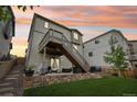 Exterior view of a two-story home with elevated deck, staircase and patio with furniture and landscaped backyard at 1607 Goldfield Trl, Castle Rock, CO 80109
