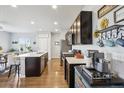 Modern kitchen featuring an island, stainless steel appliances, dark cabinetry, and wood floors at 1607 Goldfield Trl, Castle Rock, CO 80109