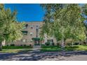 Well-maintained multi-story brick building with green awnings and landscaped front yard at 2100 N Franklin St # 15, Denver, CO 80205