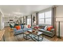 Open living room features gray sofas, wood coffee table, and large windows at 16425 Alpine Sorrel Dr, Monument, CO 80132