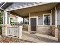 Covered front porch with white railings and a dark brown door at 168 Peabody St, Castle Rock, CO 80104