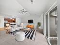 Bright living room featuring vaulted ceilings, a modern fan, a stylish rug, and an open-concept design at 10818 Cimarron St # 307, Firestone, CO 80504