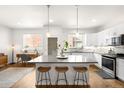 Modern kitchen features a large center island with barstool seating, sleek cabinets, and stainless appliances at 883 Widgeon Cir, Longmont, CO 80503