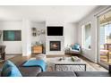 Bright living room features a modern fireplace, hardwood floors, and a sliding glass door to the balcony at 883 Widgeon Cir, Longmont, CO 80503