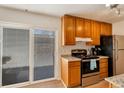 Compact kitchen featuring granite countertops, wood cabinets, and a sliding glass door at 1235 S Monaco Pkwy, Denver, CO 80224