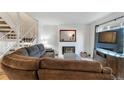 Cozy living room with fireplace and comfortable brown sofa at 1235 S Monaco Pkwy, Denver, CO 80224