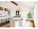 Bright dining room with white table, upholstered chairs, modern light fixture, and hard wood floors at 3624 S Poplar St, Denver, CO 80237