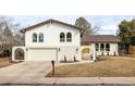 Charming two-story home with arched windows, white painted brick accents, and an attached two-car garage at 3624 S Poplar St, Denver, CO 80237