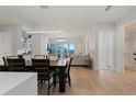 Bright dining room with modern light fixture open to living area at 155 Steele St # 917, Denver, CO 80206