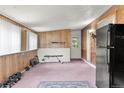 Spacious basement area with brick accents, weight bench, and exterior access door at 8991 Hickory Pl, Thornton, CO 80229