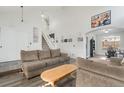 Open-concept living room with wood floors, a staircase, and bright, natural light at 5149 S Genoa Ct, Centennial, CO 80015