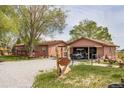 Charming exterior features two cozy home units, a Welcome sign, garage and well-manicured lawns at 6310 W County Road 4, Berthoud, CO 80513
