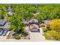 Aerial view of home with solar panels, mature trees, well-manicured lawn, and a basketball hoop at 7379 S Lafayette W Cir, Centennial, CO 80122