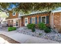 Charming brick townhome with delightful upstairs balcony and lovely rock and shrub landscaping at 2437 E Geddes Pl, Centennial, CO 80122