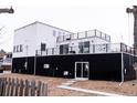 Modern home with black and white exterior, featuring an inviting backyard patio and multiple balconies with railing at 5462 S Cedar St, Littleton, CO 80120