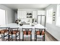 Bright kitchen featuring an island with seating, white cabinets, and modern appliances at 5462 S Cedar St, Littleton, CO 80120