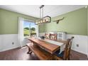 Bright dining room with wooden table and bench seating under a modern chandelier at 9916 Sand Cherry Way, Highlands Ranch, CO 80129