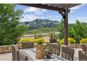 Outdoor patio dining area with pergola and scenic mountain views at 15490 W Asbury Ave, Lakewood, CO 80228