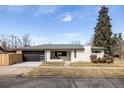 Charming single-story home featuring a modern garage door, manicured front yard, and brick facade at 3501 W 41St Ave, Denver, CO 80211