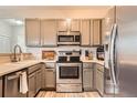 Modern kitchen with stainless steel appliances, light gray cabinetry, and updated countertops at 16320 E Fremont Ave # 1, Aurora, CO 80016