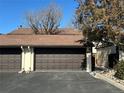 Attached garage with brown doors and an asphalt driveway on a sunny day at 12010 E Harvard Ave, Aurora, CO 80014