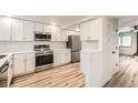 Bright, modern kitchen featuring white cabinets, stainless steel appliances, and durable countertops at 12010 E Harvard Ave, Aurora, CO 80014