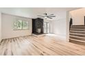 Bright living room featuring light wood floors, a stone fireplace, and a modern ceiling fan at 12010 E Harvard Ave, Aurora, CO 80014