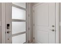 Modern entryway featuring white doors, stylish hardware, and frosted glass panel at 1990 S Holly St # 4, Denver, CO 80222