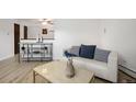 Bright living room featuring a modern sofa, stylish decor, and sleek wooden floors at 8060 W 9Th Ave # 204, Lakewood, CO 80214