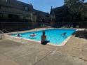 Community pool surrounded by buildings and people enjoying the water on a sunny day at 8060 W 9Th Ave # 204, Lakewood, CO 80214