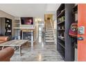 Open-concept living room with a brick fireplace, modern TV, and staircase leading to the upper level at 17694 E Loyola Dr # C, Aurora, CO 80013