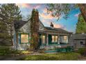 Charming two-story home with a brick chimney, a quaint covered porch, and white and blue trim at 701 W Quincy Ave, Englewood, CO 80110