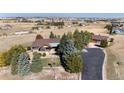 Expansive aerial view of an estate home with a long driveway and mature trees at 1505 Legacy Trl, Elizabeth, CO 80107