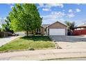 Single-Gathering home with a spacious front yard and two-car garage with a long driveway at 1115 Cherry Ct, Fort Lupton, CO 80621