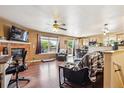 Spacious living room featuring a brick fireplace, hardwood flooring, and backyard views at 1115 Cherry Ct, Fort Lupton, CO 80621