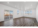 Bright living room with wood flooring, large windows, and a sliding glass door to the backyard at 3282 N Catawba Way, Aurora, CO 80019