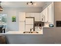 Bright kitchen featuring white cabinets, stainless sink, and modern appliances at 5455 S Dover St # 101, Littleton, CO 80123