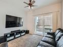 Relaxing living room with sliding door, comfortable couch, ceiling fan and entertainment center at 5455 S Dover St # 101, Littleton, CO 80123