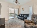 Comfortable living room with a sliding glass door to a balcony, ceiling fan, and neutral decor at 5455 S Dover St # 101, Littleton, CO 80123