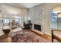 Cozy living room with hardwood floors, stone fireplace, and open access to the adjacent kitchen at 7830 W 90Th Ave # 67, Broomfield, CO 80021
