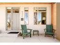 Front porch view with green chairs and a light gray front door and windows at 4330 N Raleigh St, Denver, CO 80212