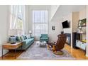 Bright living room featuring high ceilings, large windows, a cozy fireplace and hardwood flooring at 3962 Hoyt Ct, Wheat Ridge, CO 80033
