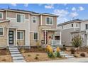 Two-story home with stone accents, red door, covered porch, and professional landscaping at 1635 S Andes Way, Aurora, CO 80017